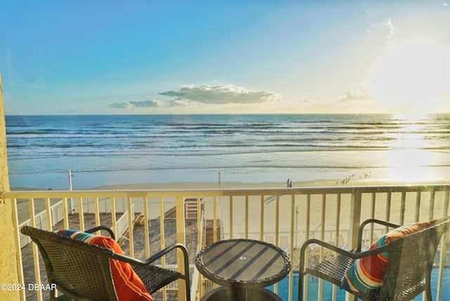 balcony featuring a view of the beach and a water view