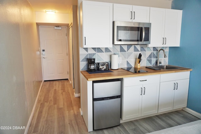 kitchen featuring sink, wooden counters, light hardwood / wood-style floors, white cabinets, and appliances with stainless steel finishes