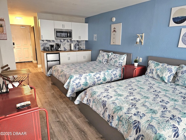 bedroom with hardwood / wood-style floors and sink