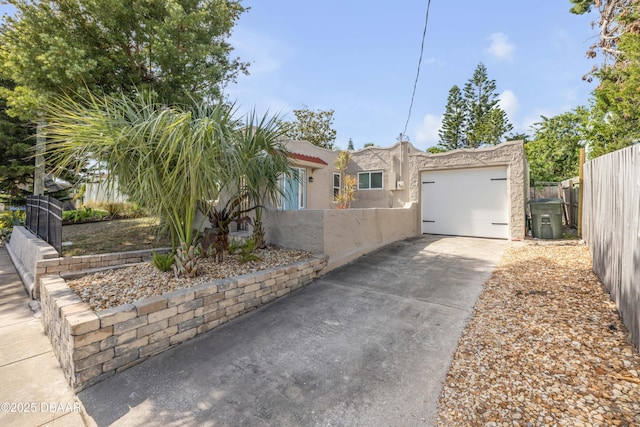 view of front of house featuring fence private yard, a garage, stucco siding, and concrete driveway
