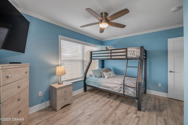 bedroom featuring baseboards, ornamental molding, and light wood finished floors
