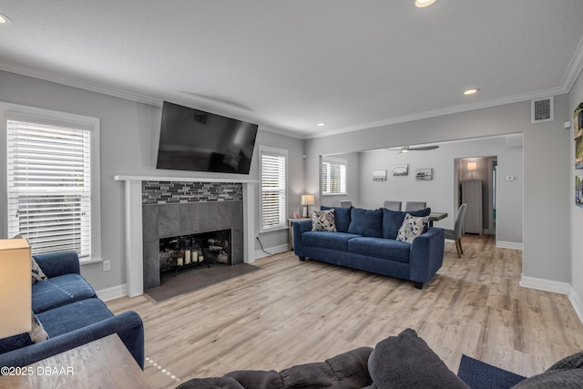 living room featuring visible vents, ornamental molding, and baseboards