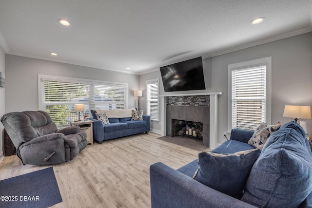 living room featuring recessed lighting, a fireplace with flush hearth, ornamental molding, and wood finished floors