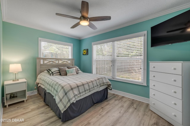 bedroom with baseboards, ornamental molding, a ceiling fan, and light wood-type flooring