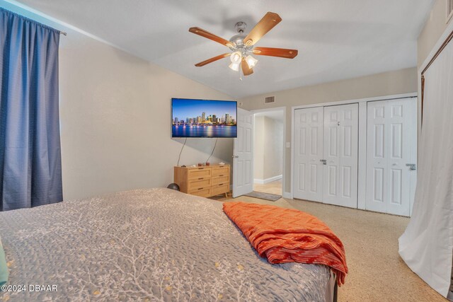 bedroom with lofted ceiling, ceiling fan, visible vents, and multiple closets