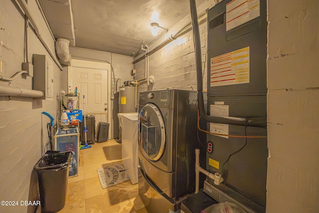 washroom featuring laundry area, water heater, independent washer and dryer, heating unit, and concrete block wall