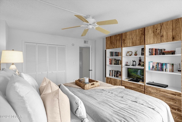 bedroom with a textured ceiling, ceiling fan, and a closet