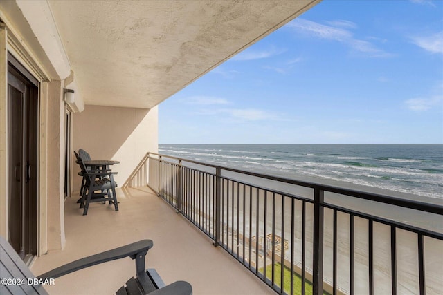 balcony featuring a beach view and a water view