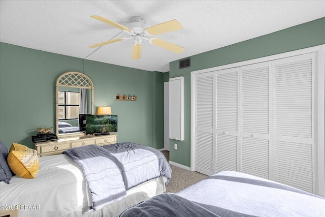 bedroom with a textured ceiling, carpet, and ceiling fan