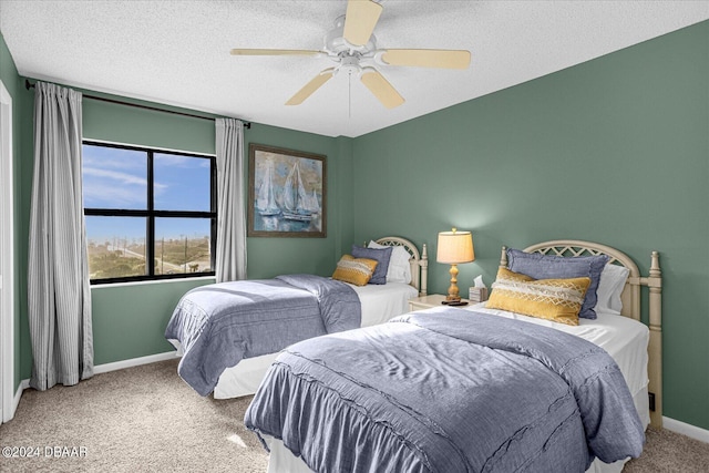 carpeted bedroom with ceiling fan and a textured ceiling