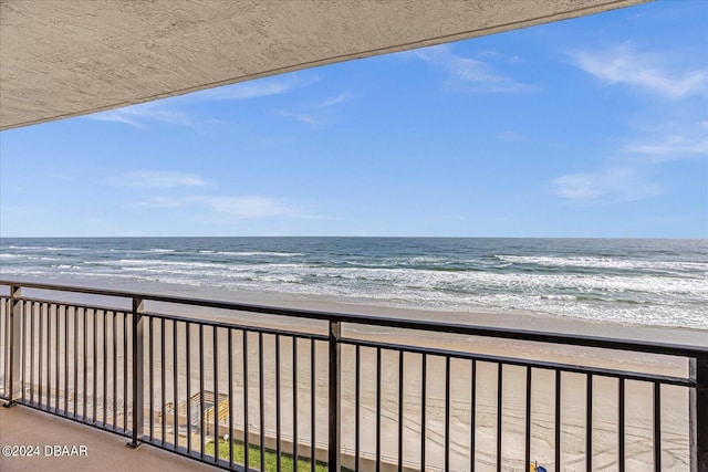 balcony with a water view and a beach view