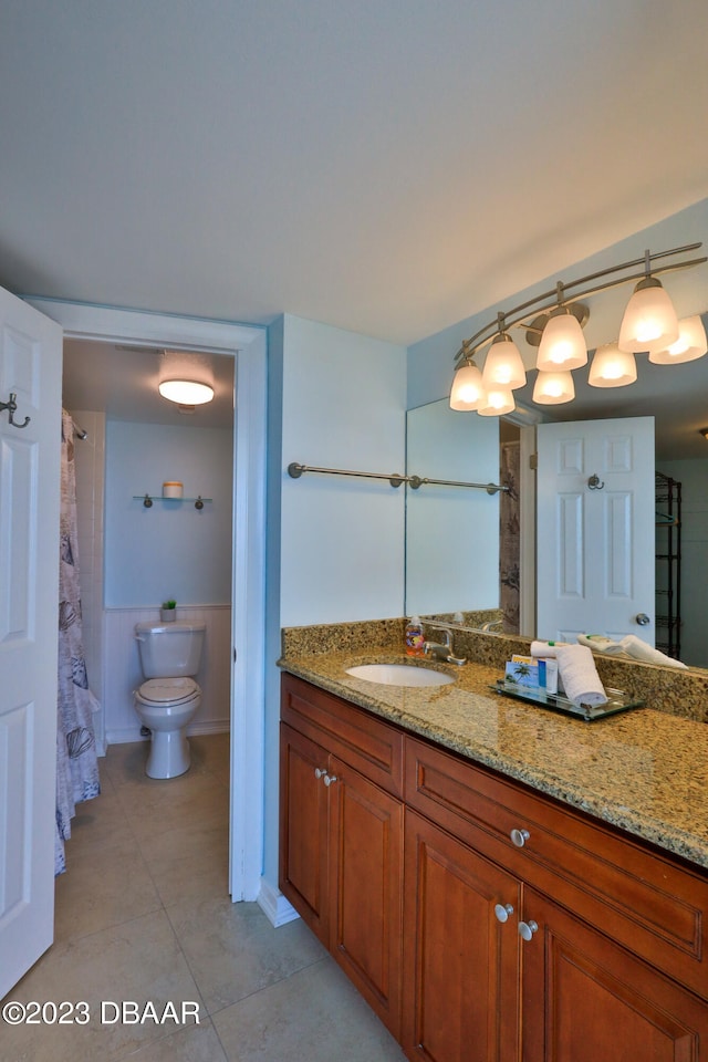 bathroom with toilet, tile patterned floors, and vanity