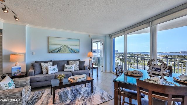 tiled living room with a textured ceiling, crown molding, and a water view