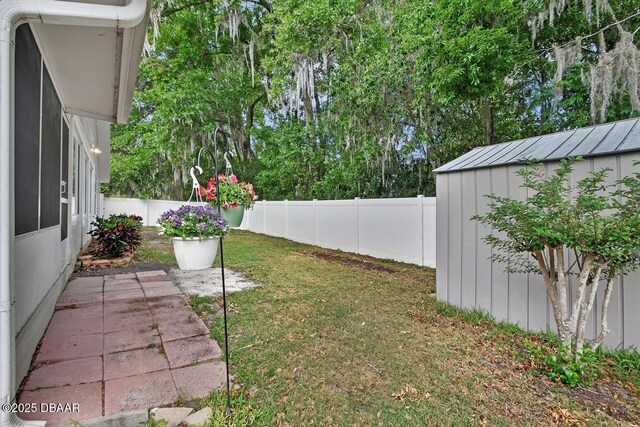 view of yard featuring a fenced backyard, an outbuilding, and a storage unit