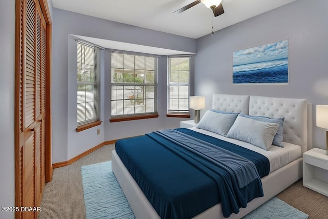 carpeted bedroom with baseboards, a ceiling fan, and a closet