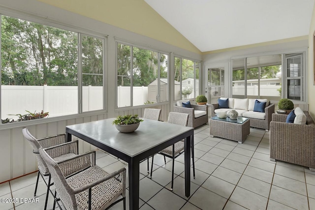 sunroom featuring vaulted ceiling, a wealth of natural light, tile patterned flooring, and an outdoor hangout area