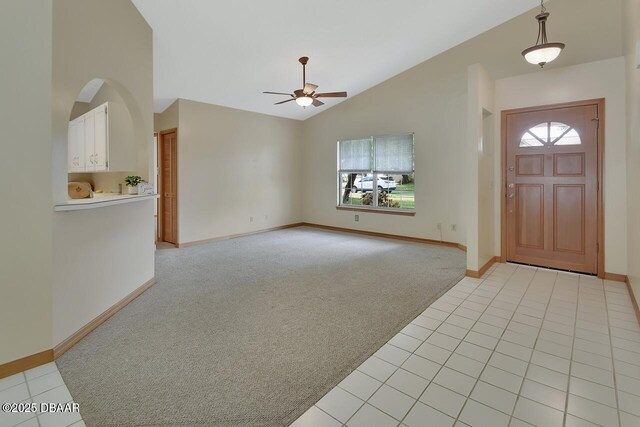 entryway featuring light carpet, baseboards, and ceiling fan