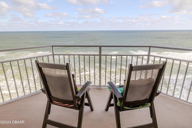 balcony featuring a water view and a beach view