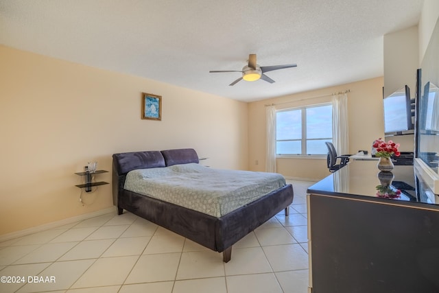 tiled bedroom featuring ceiling fan and a textured ceiling