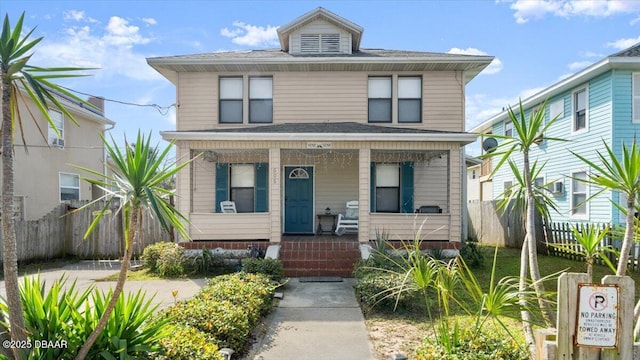 traditional style home with a porch and fence