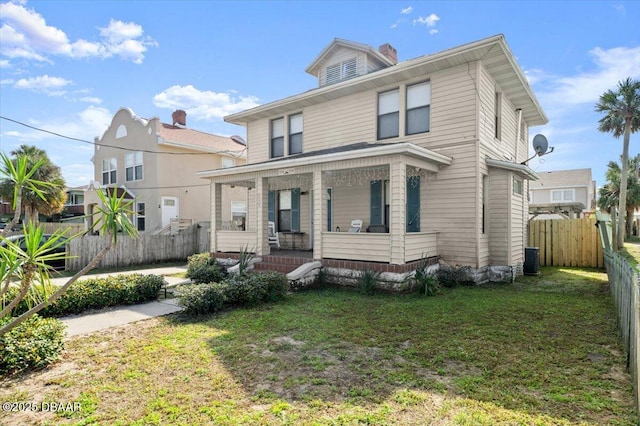 traditional style home featuring central AC unit, covered porch, fence, a front lawn, and a chimney