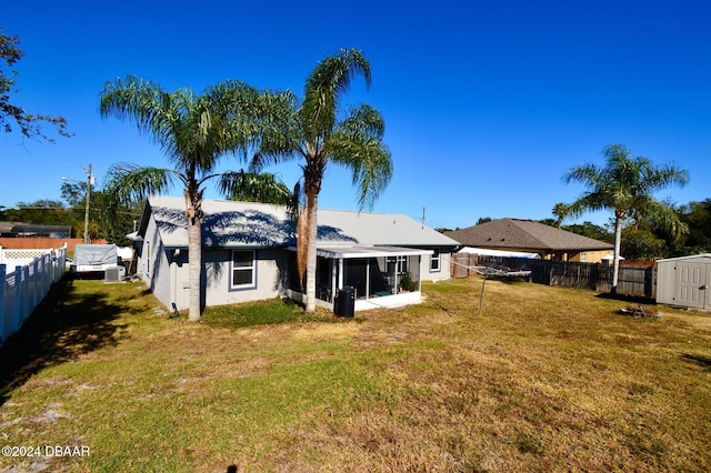 rear view of house featuring a yard and a sunroom