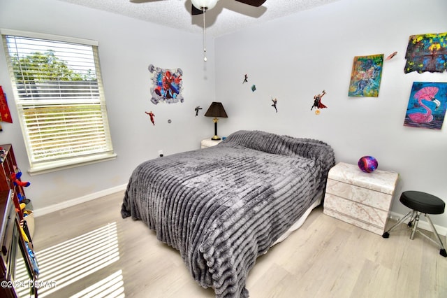 bedroom featuring ceiling fan, a textured ceiling, and light hardwood / wood-style floors