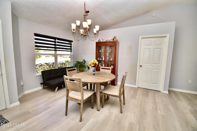 dining space with lofted ceiling, a notable chandelier, light hardwood / wood-style flooring, and a textured ceiling