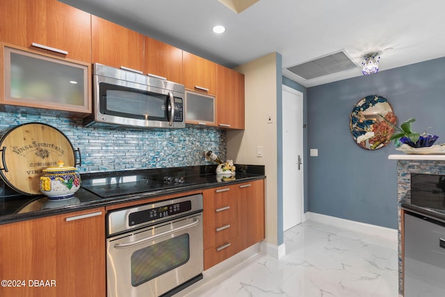 231 Riverside Dr Unit 1803-1, Daytona Beach, FL 32117 - kitchen featuring stainless steel appliances, brown cabinets, baseboards, glass insert cabinets, and decorative backsplash