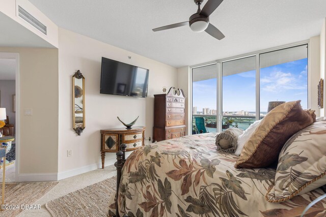 231 Riverside Dr Unit 1803-1, Daytona Beach, FL 32117 - carpeted bedroom featuring access to outside, baseboards, a ceiling fan, and expansive windows