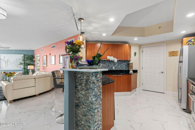 231 Riverside Dr Unit 1803-1, Daytona Beach, FL 32117 - kitchen featuring brown cabinetry, recessed lighting, open floor plan, light marble finish floors, and dark countertops