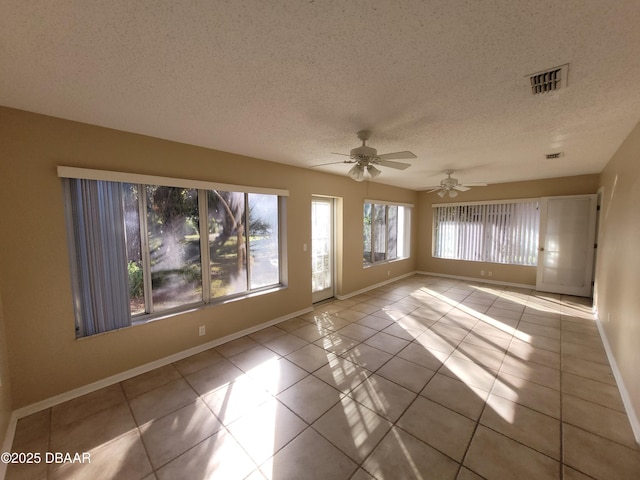 unfurnished room with visible vents, a ceiling fan, a textured ceiling, baseboards, and tile patterned floors