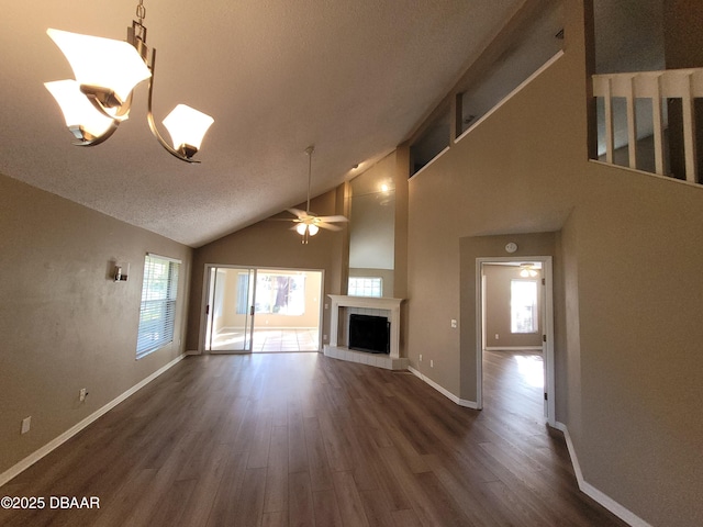 unfurnished living room featuring baseboards, a ceiling fan, dark wood finished floors, and a tiled fireplace