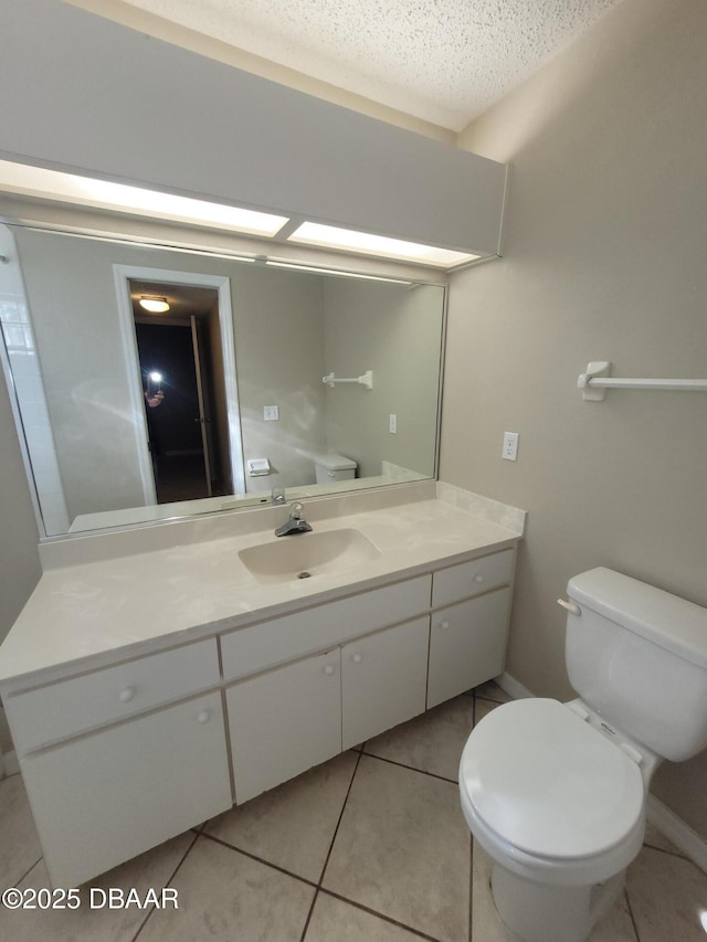 bathroom featuring toilet, tile patterned flooring, a textured ceiling, and vanity