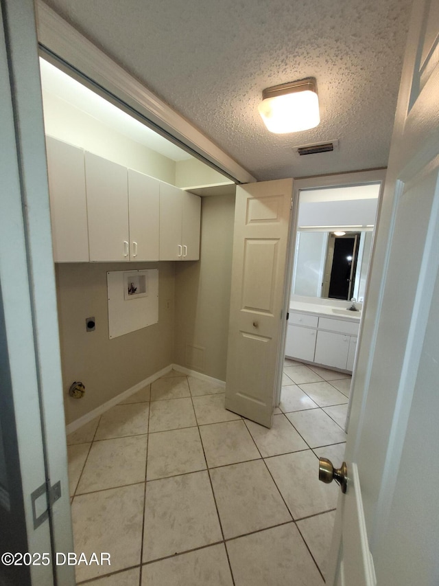 laundry room featuring light tile patterned floors, hookup for a washing machine, visible vents, cabinet space, and electric dryer hookup