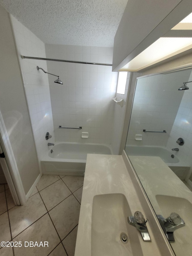 bathroom with a textured ceiling, bathtub / shower combination, a sink, baseboards, and tile patterned floors