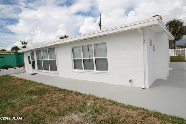 view of home's exterior featuring a patio area and a lawn