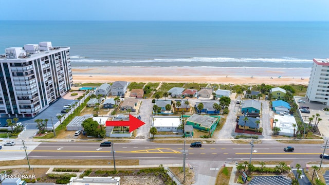 birds eye view of property featuring a water view and a beach view