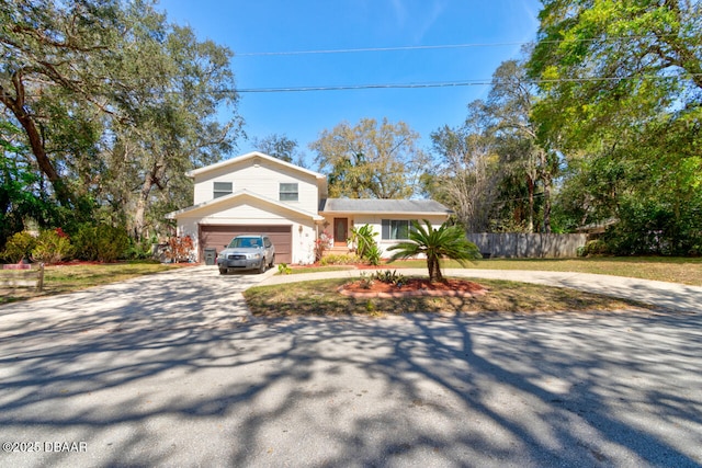 view of front facade with a garage, fence, and driveway