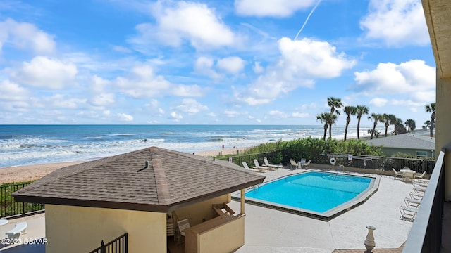 view of pool featuring a view of the beach and a water view