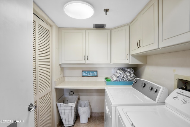 laundry area featuring light tile patterned flooring, cabinets, and independent washer and dryer