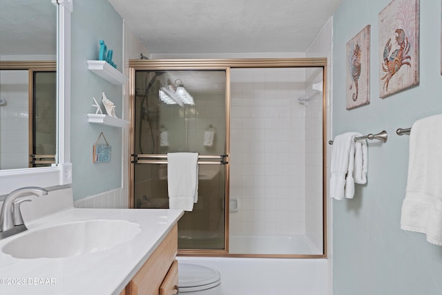 full bathroom featuring vanity, enclosed tub / shower combo, and toilet