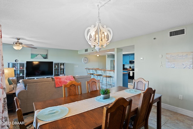 dining room featuring a textured ceiling, ceiling fan with notable chandelier, and light tile patterned floors