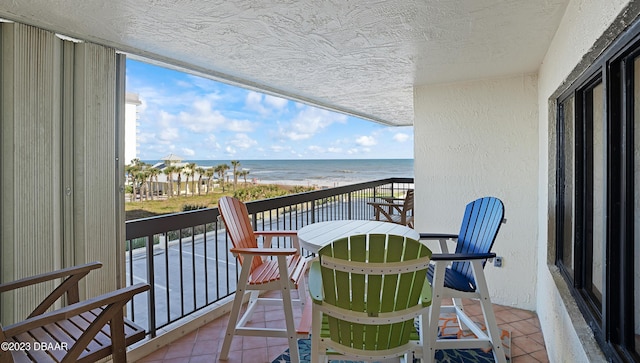 balcony featuring a water view and a view of the beach