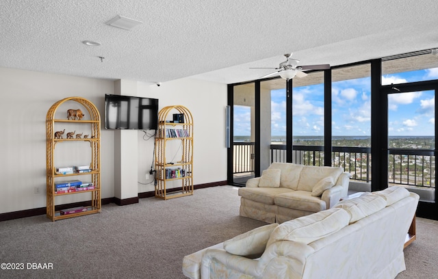 carpeted living room featuring a textured ceiling, a wall of windows, and ceiling fan