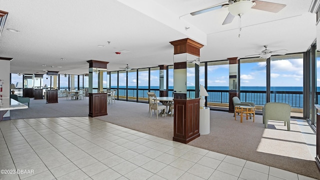 interior space with ceiling fan and a water view