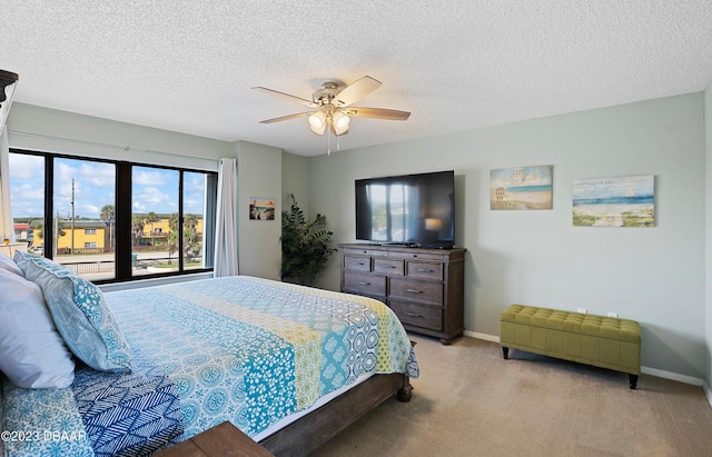 bedroom featuring ceiling fan, light colored carpet, and a textured ceiling