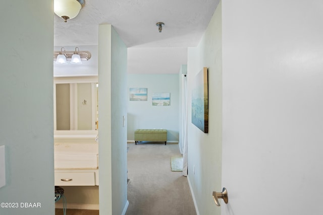 hall featuring a textured ceiling and light carpet