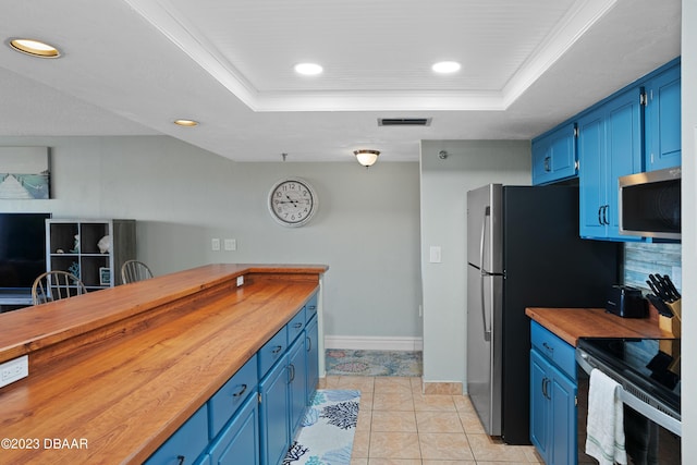 kitchen featuring a raised ceiling, light tile patterned floors, blue cabinets, and range