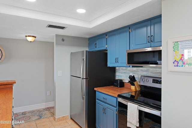 kitchen featuring backsplash, a raised ceiling, blue cabinets, light tile patterned floors, and stainless steel appliances